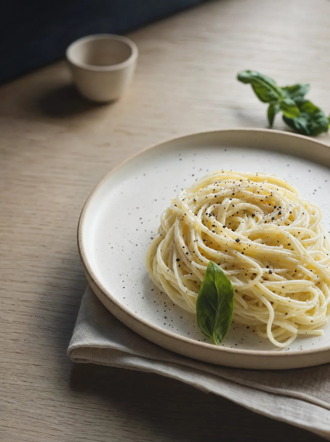 A plated bowl of egg white spaghetti with tomato and basil