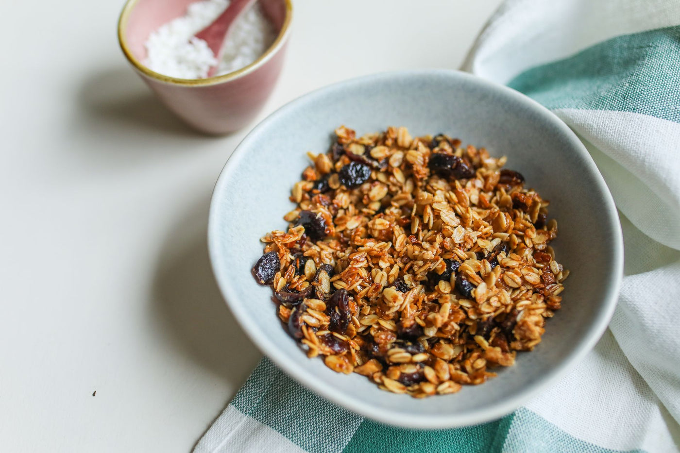 A bowl of fiber-rich granola and oats on a linen cloth in soft light